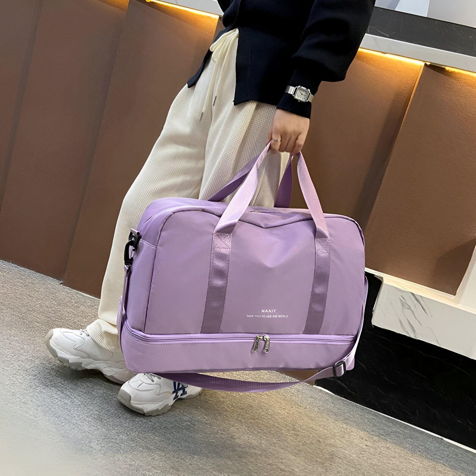 Un sac de voyage violet avec la marque "MANIY" et le slogan "TAKE YOU TO SEE THE WORLD" sur le devant.