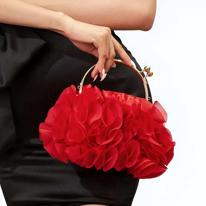 Pochette de soirée rouge avec volants floraux et fermoir doré, portée par une personne en robe noire., 46193932239072,46193932271840,46193932304608,46193932337376