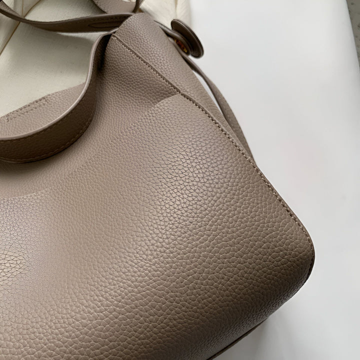 Détail du coin d'un sac en cuir grainé couleur taupe., 46193878270176,46193878302944,46193878335712,46193878368480