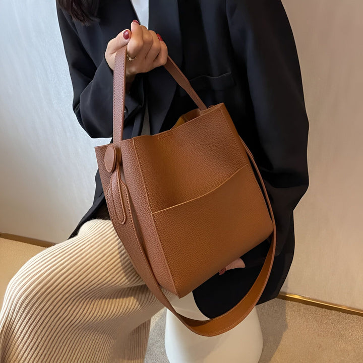 Sac seau marron en cuir grainé porté par une femme., 46193878270176,46193878302944,46193878335712,46193878368480