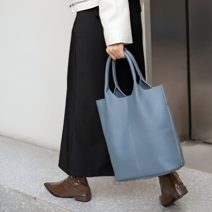 Femme portant un grand sac cabas en cuir bleu ciel et des bottes marron., 46193872404704,46193872437472,46193872470240,46193872503008,46193872535776