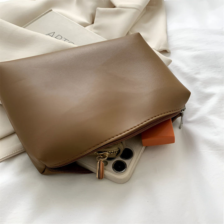 Pochette marron zippée ouverte contenant un téléphone et un objet orange., 46193879515360,46193879548128,46193879580896,46193879613664,46193879646432