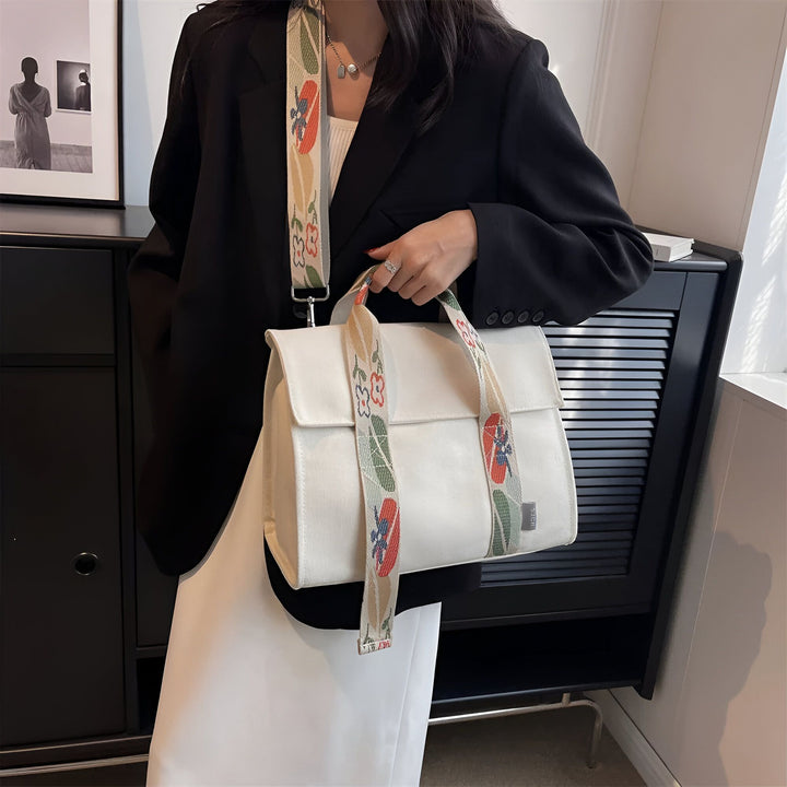 Femme tenant un sac tote blanc avec une bandoulière à motifs floraux., 46193894555872,46193894588640,46193894621408,46193894654176,46193894686944
