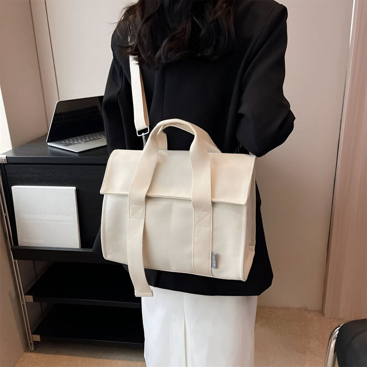 Une personne porte un grand sac tote bag crème sur l'épaule avec une veste noire et une jupe blanche., 46193894555872,46193894588640,46193894621408,46193894654176,46193894686944