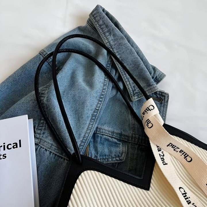 Veste en jean bleue pliée, livre blanc, sac beige texturé avec lanières., 46193872208096,46193872240864,46193872273632,46193872306400