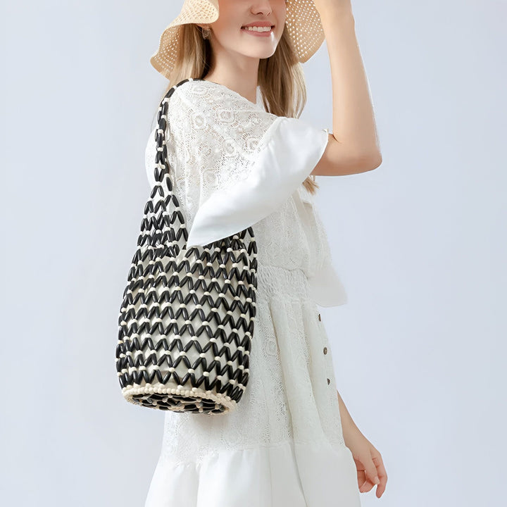 Sac à perles noir et blanc porté par une femme en robe et chapeau., 46193944821984,46193944854752,46193944887520,46193944920288