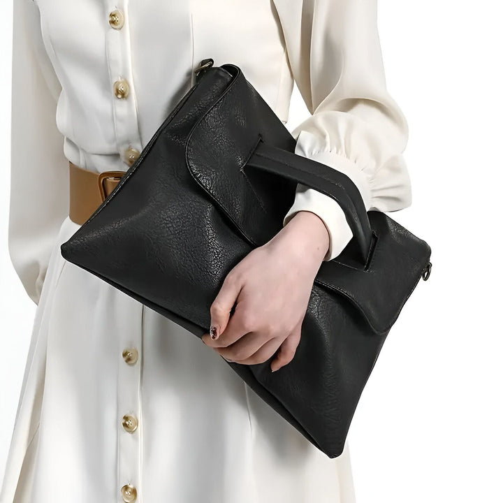 Sac pochette noir porté à la main avec une robe blanche., 46194020417760,46194020450528,46194020483296,46194020516064