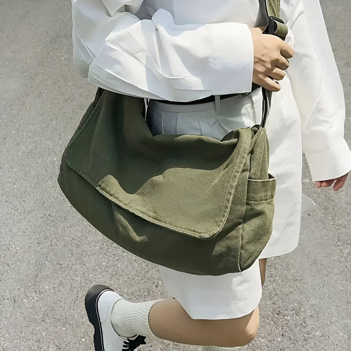 Sac bandoulière en toile vert kaki porté par une personne en tenue blanche., 46193883152608,46193883185376,46193883218144