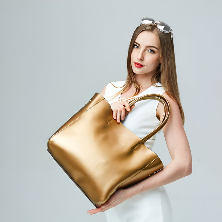 Femme en robe blanche tenant un grand sac fourre-tout doré., 46193841406176,46193841438944,46193841471712,46193841504480,46193841537248
