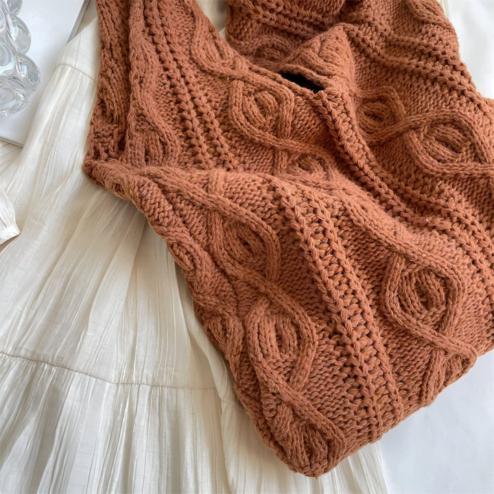 Sac tricoté rouille à torsades posé sur un tissu plissé blanc., 46193946886368,46193946919136,46193946951904,46193946984672,46193947017440