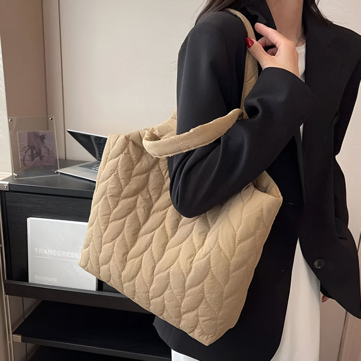 Sac tote matelassé beige avec motif feuille, porté à l'épaule par une femme., 46194049712352,46194049745120,46194049777888,46194049810656