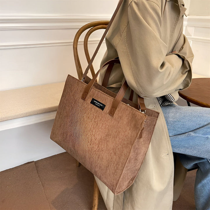 Sac tote bag marron en velours côtelé porté par une personne en trench beige et jeans., 46194056757472,46194056790240,46194056823008,46194056855776