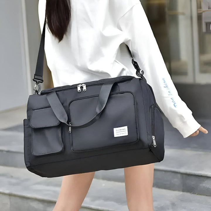 Sac de sport noir porté en bandoulière par une personne, 46193915625696,46193915658464,46193915691232,46193915724000,46193915756768,46193915789536
