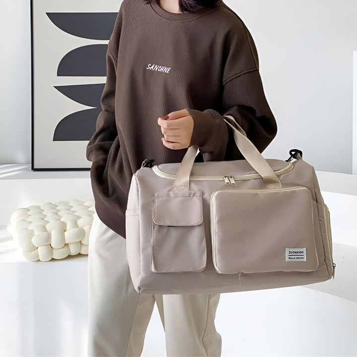 Femme avec un sac de voyage beige multi-poches., 46193915625696,46193915658464,46193915691232,46193915724000,46193915756768,46193915789536
