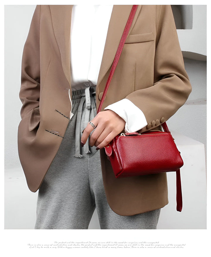 Sac bandoulière rouge porté par une femme en blazer beige., 46266441924832,46266441957600,46266441990368