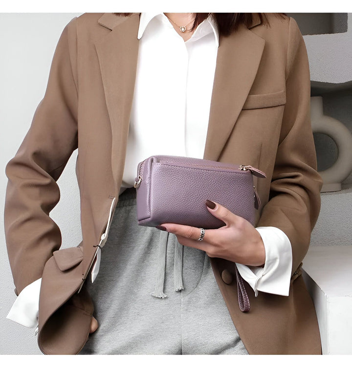 Femme tenant une pochette violette en cuir grainé., 46266441924832,46266441957600,46266441990368
