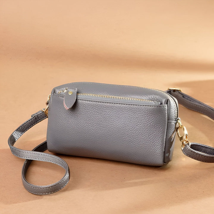 Sac bandoulière gris en cuir avec fermeture éclair dorée et lanière., 46266441924832,46266441957600,46266441990368