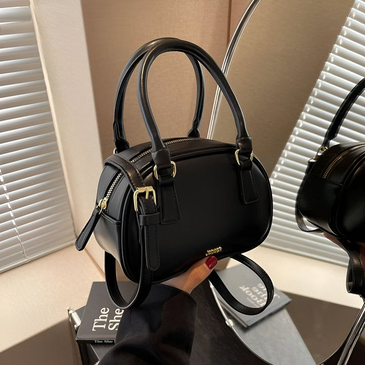 Sac à main noir forme cylindre avec double poignée, fermetures éclair et boucles dorées., 46262992044256,46262992077024,46262992109792,46262992142560,46262992175328