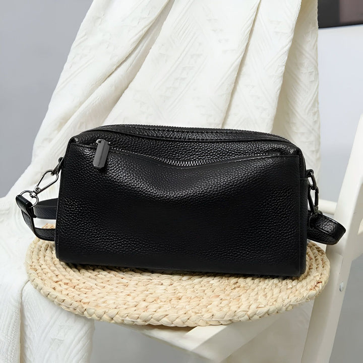 Sac bandoulière en cuir noir grainé, avec poches zippées, sur fond blanc., 46266441760992,46266441793760