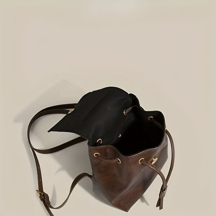 Sac à dos marron en cuir avec doublure noire, cordon de serrage et détails dorés., 46194001805536,46194001838304