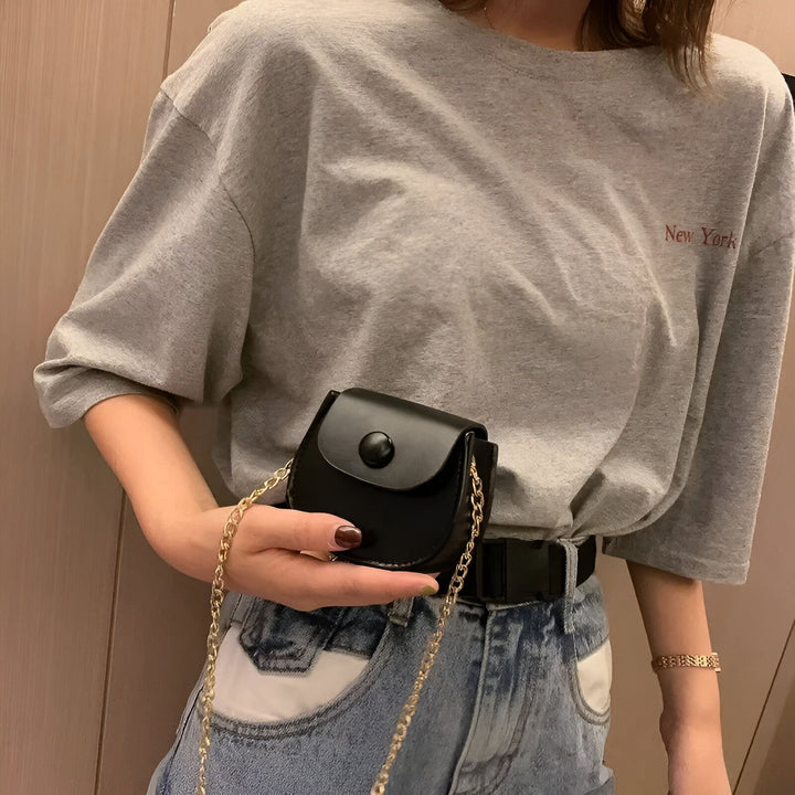 Femme en t-shirt gris et jean portant un petit sac noir en similicuir à rabat, chaîne dorée., 46193969856736,46193969889504,46193969922272,46193969955040,46193969987808,46193970020576