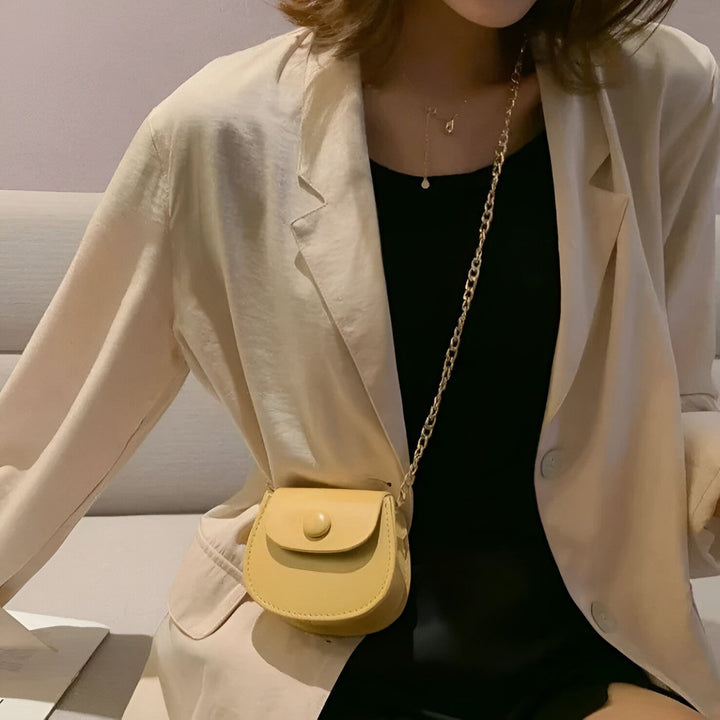 Femme portant un blazer beige, un haut noir et un petit sac jaune à chaîne dorée., 46193969856736,46193969889504,46193969922272,46193969955040,46193969987808,46193970020576