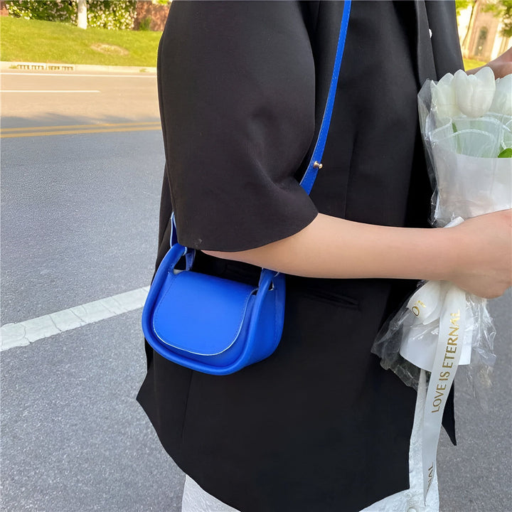 Femme avec blazer noir et petit sac bandoulière bleu tenant des tulipes blanches, 46193971232992,46193971265760,46193971298528,46193971364064,46193971396832
