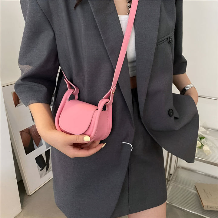 Petit sac à bandoulière rose porté avec un ensemble gris., 46193971232992,46193971265760,46193971298528,46193971364064,46193971396832