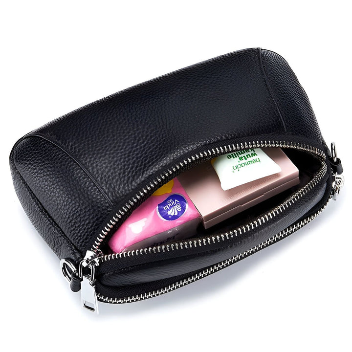 Trousse de toilette en cuir noir ouverte montrant mouchoirs, maquillage et crème., 46266442121440,46266442154208,46266442186976,46266442219744,46266442252512