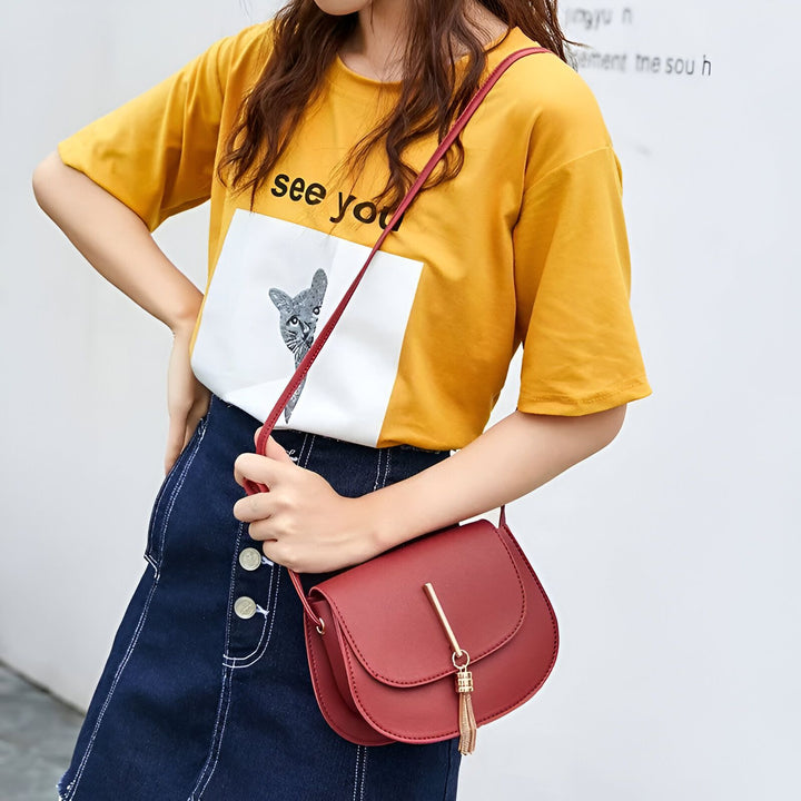 Petit sac bandoulière rouge avec pompon doré porté par une femme, 46262994567392,46262994600160,46262994632928,46262994665696,46262994698464,46262994731232