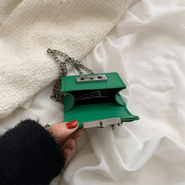Sac vert ouvert avec chaîne argentée tenu par une main, montrant des épingles à cheveux., 46193972642016,46193972674784,46193972707552,46193972740320,46193972773088,46193972805856
