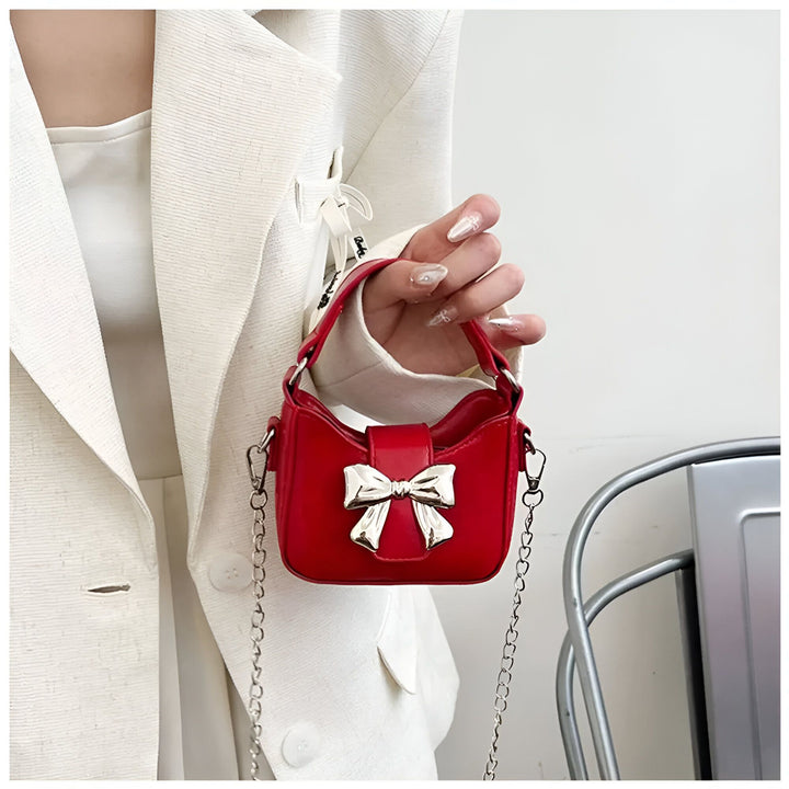 Petite pochette rouge avec nœud argenté tenue à la main, 46262992732384,46262992765152,46262992797920,46262992830688,46262992863456