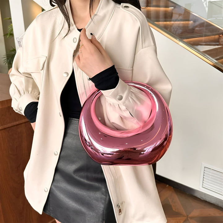 Femme tenant un sac à main rond rose brillant avec une veste beige, 46194015502560,46194015535328,46194015568096,46194015600864,46194015633632,46194015666400