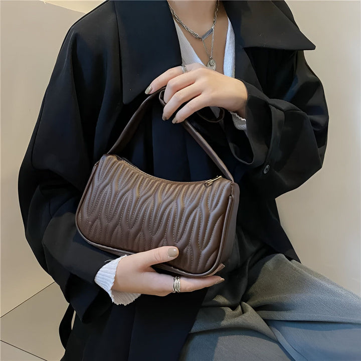 Sac baguette matelassé marron porté par une personne, 46193961631968,46193961664736,46193961730272,46193961763040,46193961795808