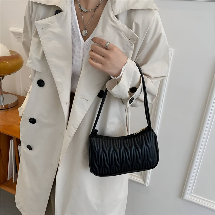 Personne en trench coat clair tenant un sac à main noir texturé., 46193961631968,46193961664736,46193961730272,46193961763040,46193961795808