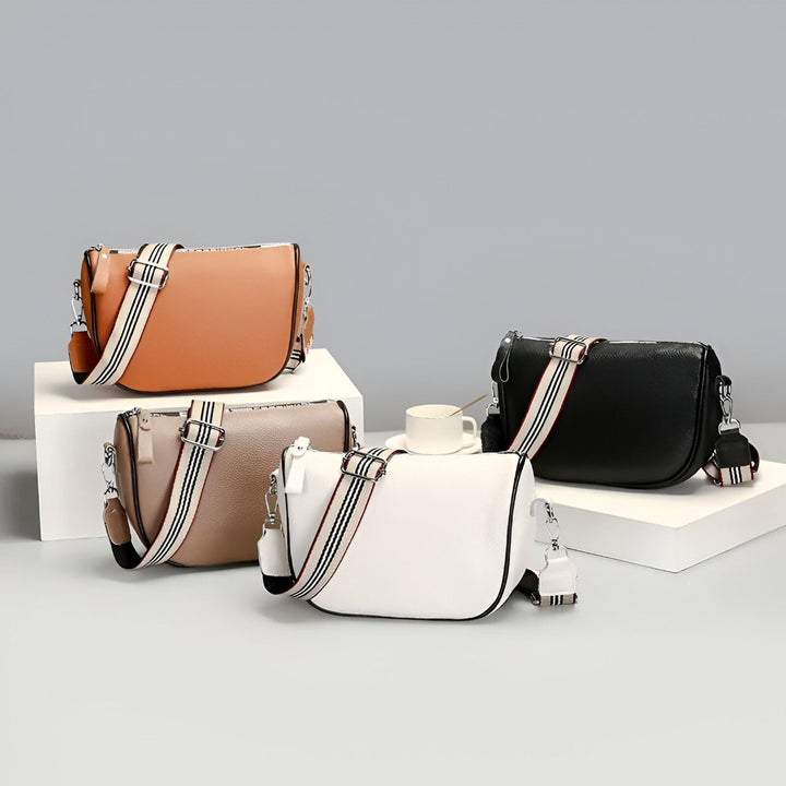 Quatre sacs à main en cuir sur socles blancs (camel, beige, blanc, noir) avec bandoulières rayées., 46262995747040,46262995779808,46262995812576,46262995845344