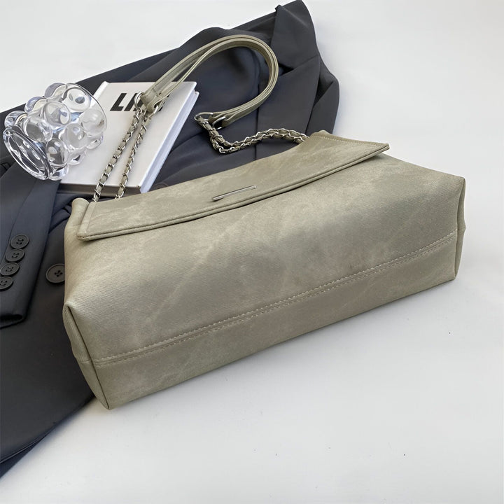 Sac à main gris clair avec chaîne posé sur un blazer gris foncé., 46193885544672,46193885577440,46193885610208,46193885642976