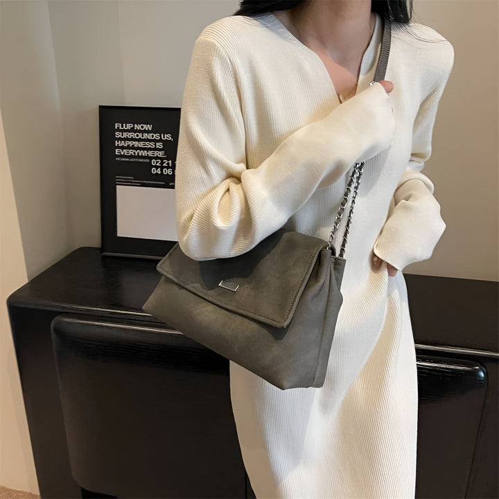 Femme en robe blanche côtelée tenant un sac à main gris foncé en suédine avec chaîne., 46193885544672,46193885577440,46193885610208,46193885642976