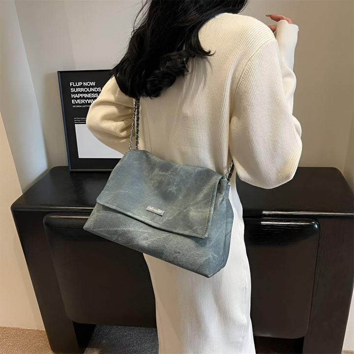 Sac bandoulière gris-bleu texturé avec chaîne argentée, porté par une femme, 46193885544672,46193885577440,46193885610208,46193885642976