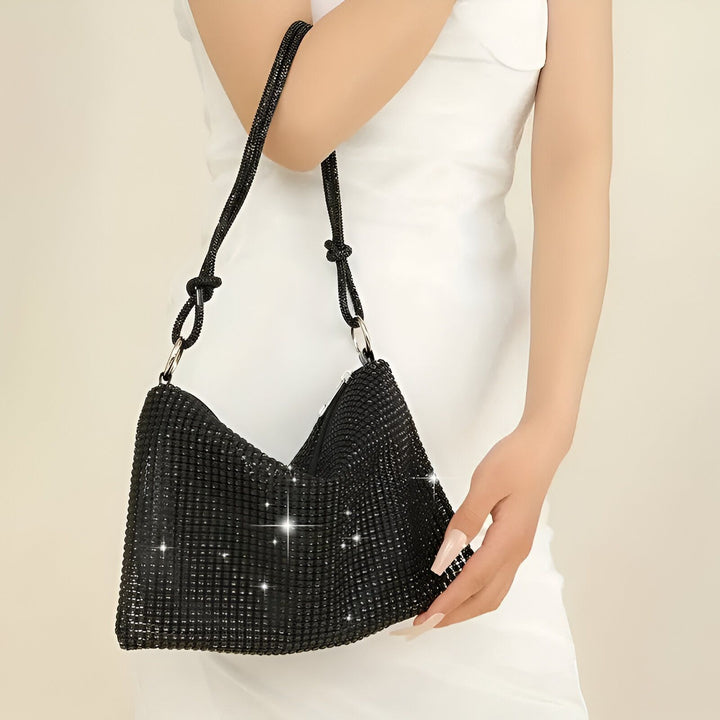 Sac à main noir brillant à bandoulière porté par une femme en robe blanche., 46194028642528,46194028675296,46194028708064