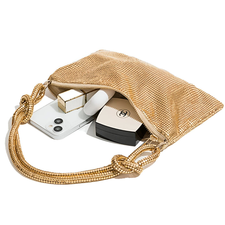 Sac à main doré en maille métallique avec anse nouée, contenant téléphone, écouteurs et compact Chanel., 46194028642528,46194028675296,46194028708064