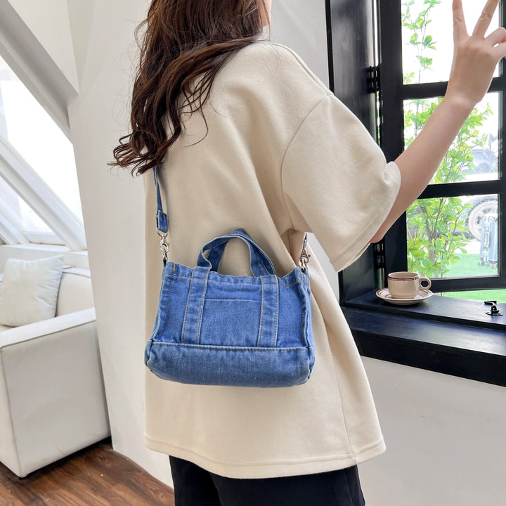 Petit sac bandoulière en jean bleu porté par une personne de dos., 46193993285856,46193993318624