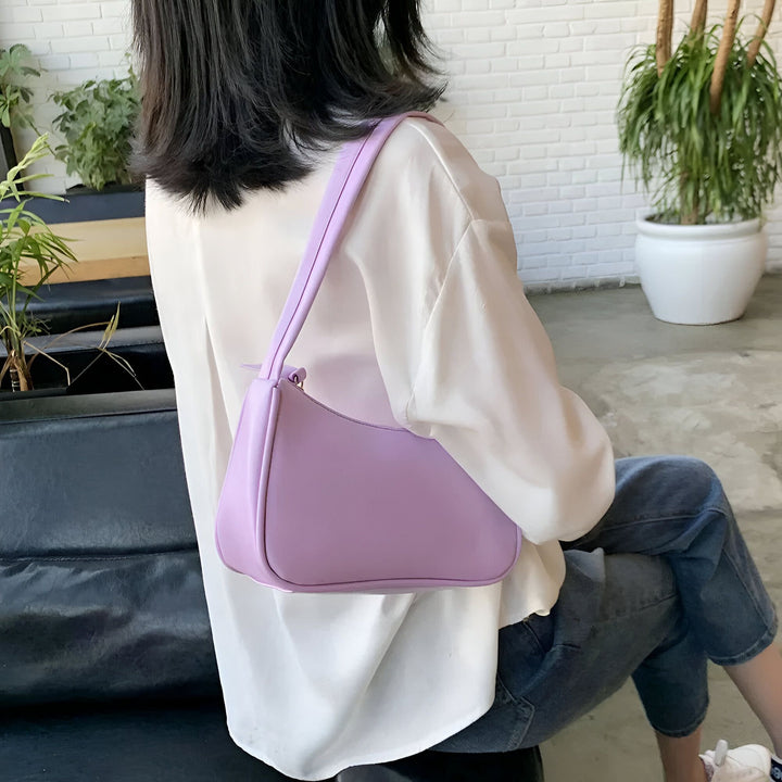 Femme de dos avec chemisier blanc et jean, portant un sac baguette violet clair sur l'épaule., 46193965596896,46193965629664,46193965662432,46193965695200,46193965727968,46193965760736,46193965793504