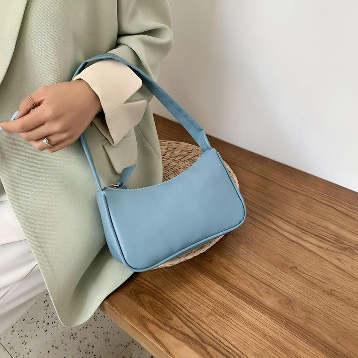 Sac baguette bleu clair tenu par une main., 46193965596896,46193965629664,46193965662432,46193965695200,46193965727968,46193965760736,46193965793504