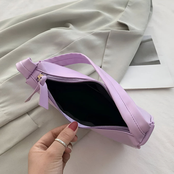 Sac à main lilas ouvert tenu par une main, sur fond gris., 46193965596896,46193965629664,46193965662432,46193965695200,46193965727968,46193965760736,46193965793504