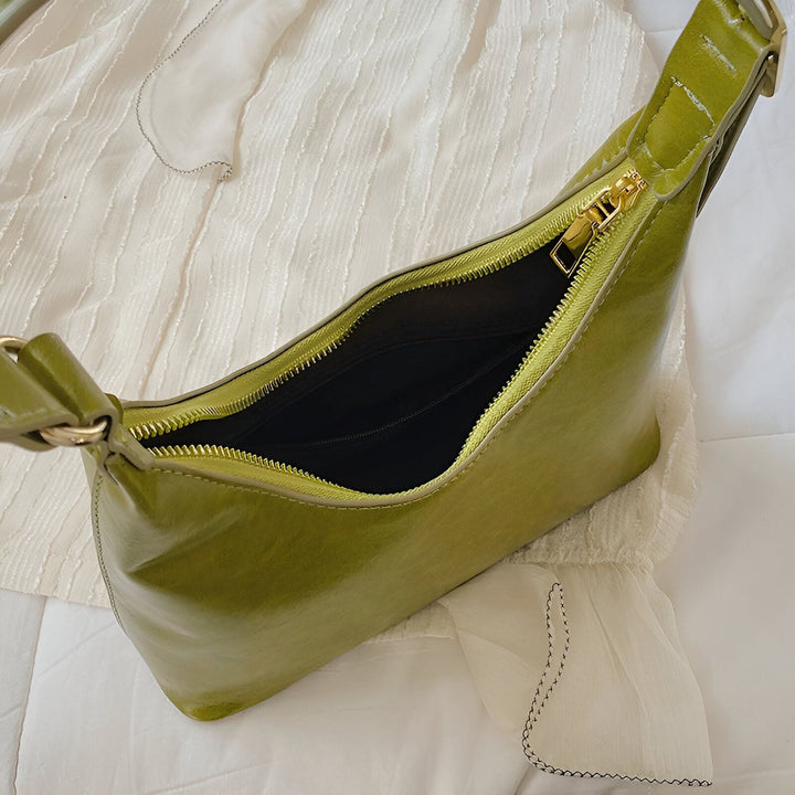 Sac à main baguette vert brillant ouvert avec fermeture éclair dorée sur un tissu blanc froissé., 46193942495456,46193942528224,46193942560992
