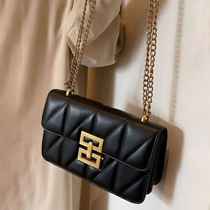 Sac à main noir matelassé avec fermoir doré et chaîne en or., 46193949049056