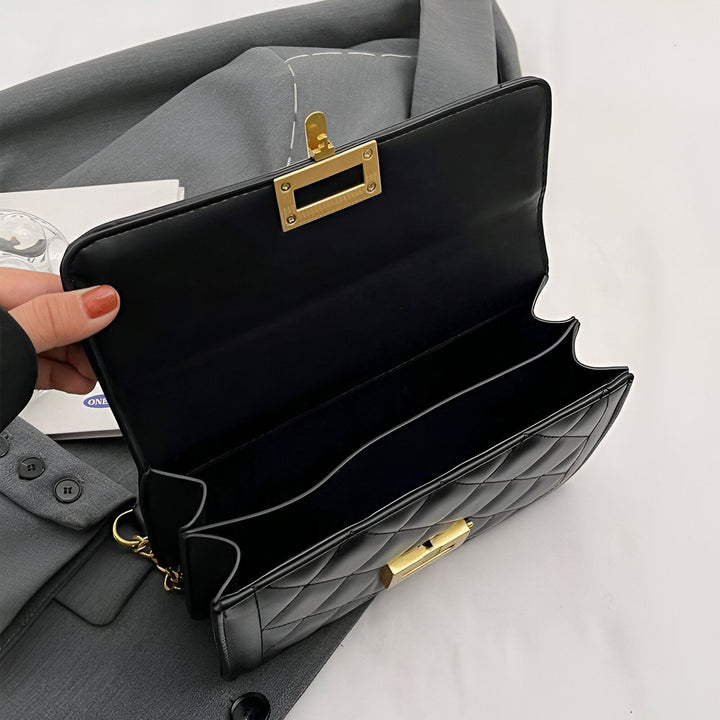 Sac à main noir matelassé ouvert avec fermoirs dorés, montrant l'intérieur., 46193949049056