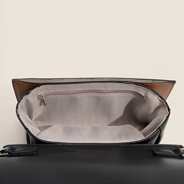Vue de l'intérieur d'un sac à main noir ouvert, montrant la doublure à motifs et une poche intérieure zippée., 46194016420064