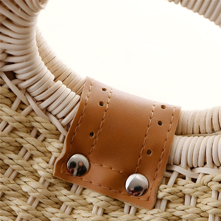 Détail d'une attache en cuir marron avec rivets argentés sur un sac en paille., 46193945706720,46193945739488,46193945772256,46193945805024,46193945837792